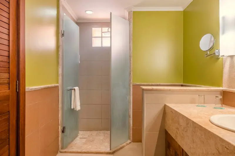 Banheiro de junior suite com box de chuveiro e espelho de aumento