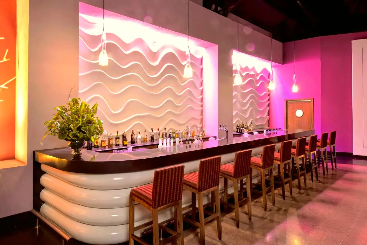 Balcão de bar com banquetas e iluminação colorida