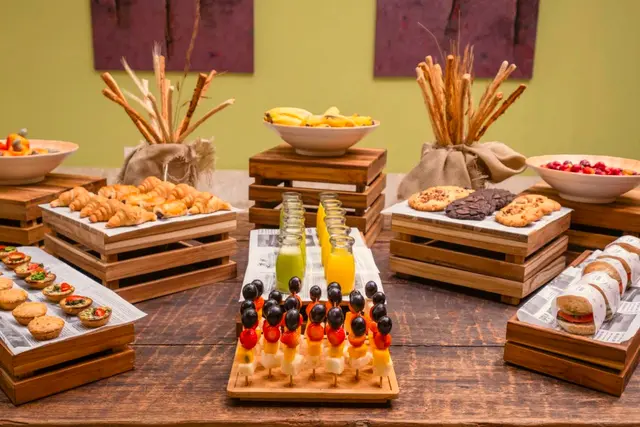 Bufê de café da manhã com pães, bolos, frutas e sucos