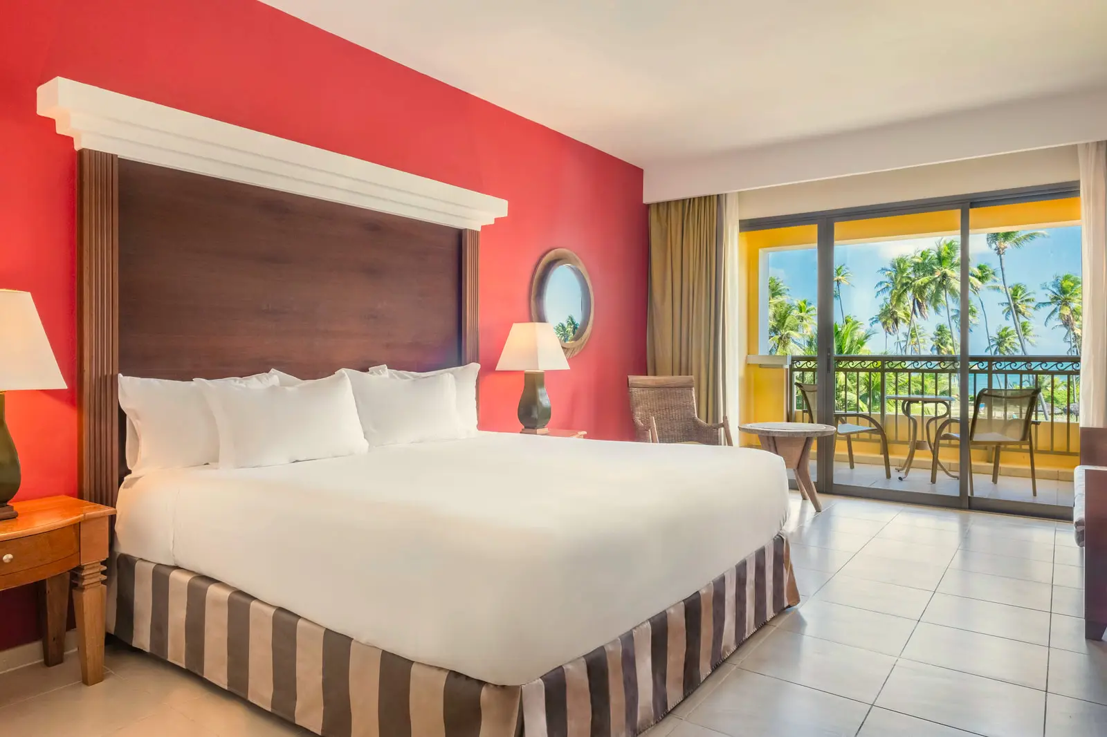 Junior suite com cama king, parede vermelha e varanda