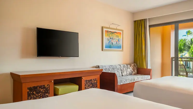 Junior suite com sofá, smart TV e duas camas