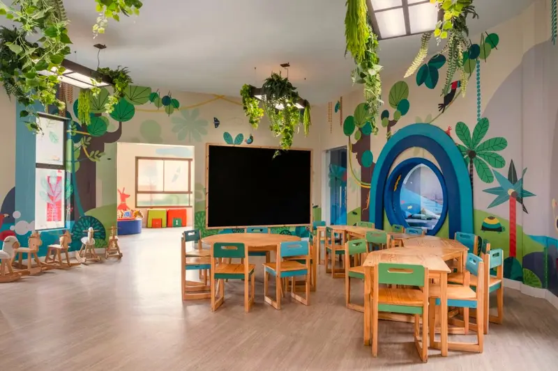 Sala do Star Camp com mesas infantis e paredes ilustradas