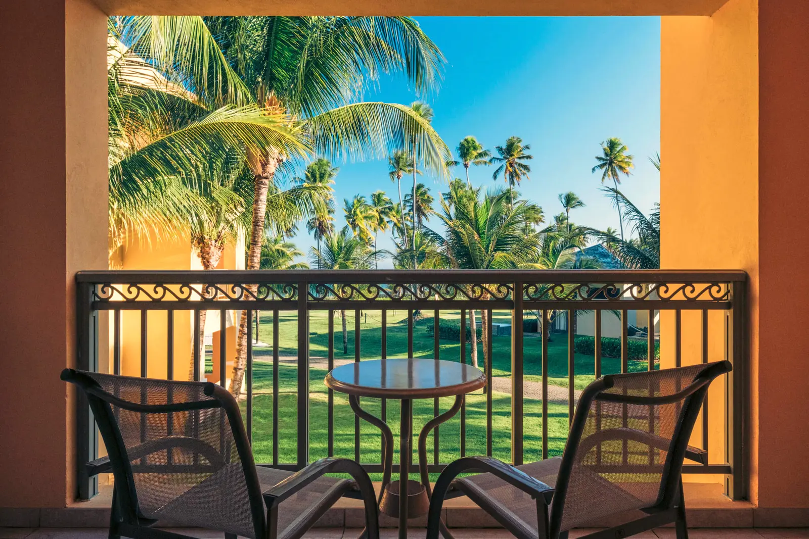 Varanda com mesa e duas cadeiras voltada para o jardim