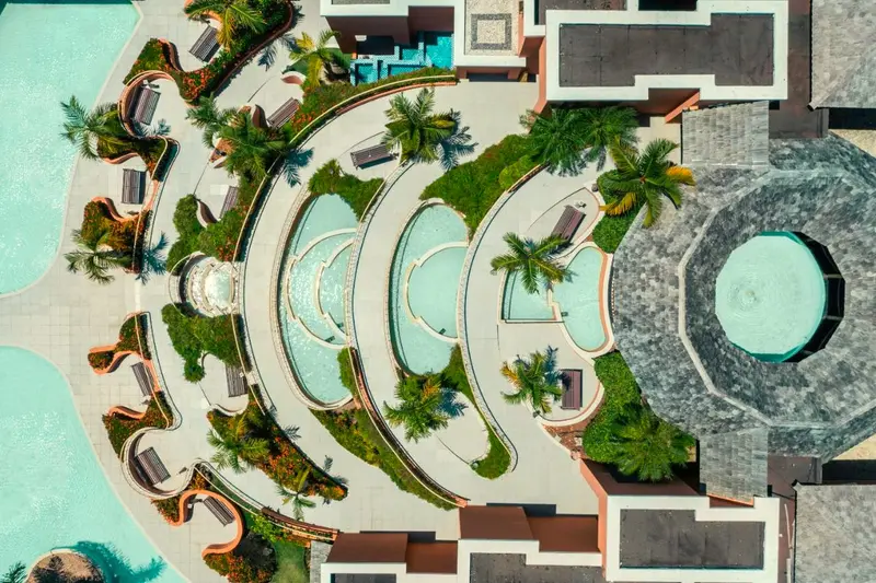 Vista aérea de piscinas em níveis cercadas de jardins
